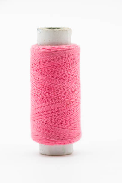istock single pink color  yarn or spool thread  over on background 1396073747