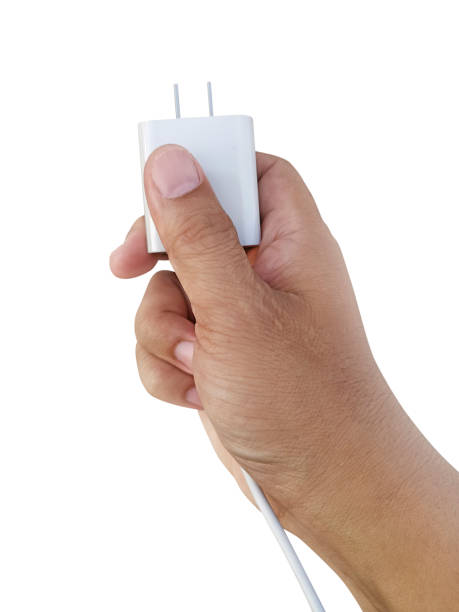パワープラグスマートフォンの白い背景を持つ手 - mobile phone charging power plug adapter ストックフォトと画像