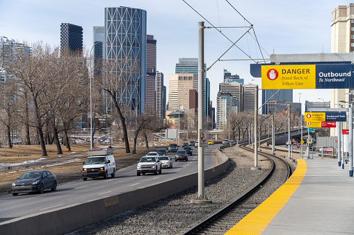 Calgary, AB, Canada - March 14 2022 : Bridgeland Memorial station platform. CTrain light rail system. Traffic on Memorial Drive.