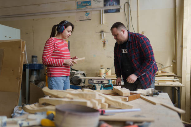 istock a man and a woman work in a carpentry shop 1396081805