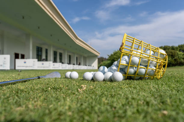 una canasta de pelotas de golf derramadas sobre el césped - short game fotografías e imágenes de stock