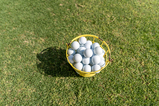 A basket of golf balls on the lawn