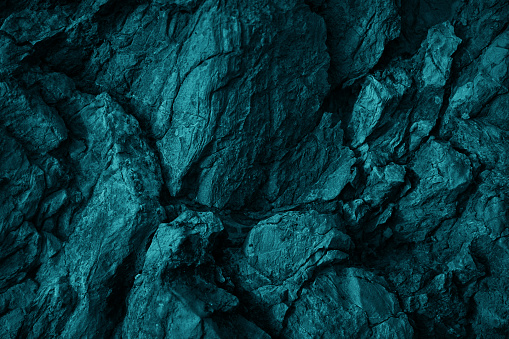 Green blue rock texture. Toned rough mountain surface texture. Crumbled. Close-up.