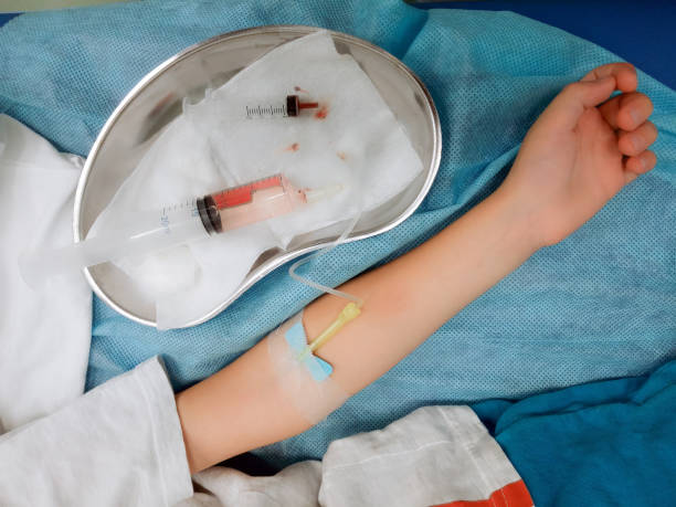 Taking blood from a vein in a child's arm. Taking a blood test. stock photo