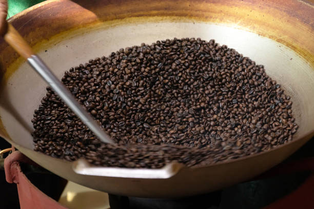 istock Roasting natural ground coffee beans process in the original local equipment components coffee roasting machine. 1396084282
