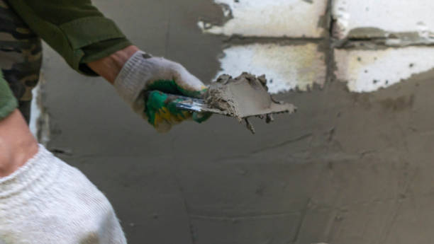 istock Plastering cement at wall for renovation house. Plasterer smoothing plaster on wall. Putty brick wall background 1396084473