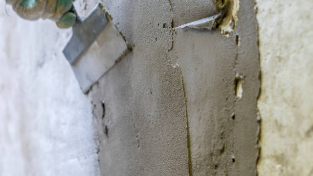 istock A plasterer applies plaster with a spatula to a brick wall. Wall renovation process. Defocused background. 1396084487