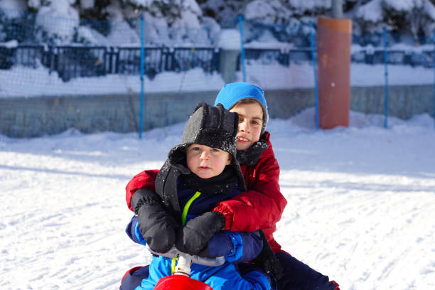 istock Two little brothers having fun with sled, Ilgaz, Turkey. 1396084524