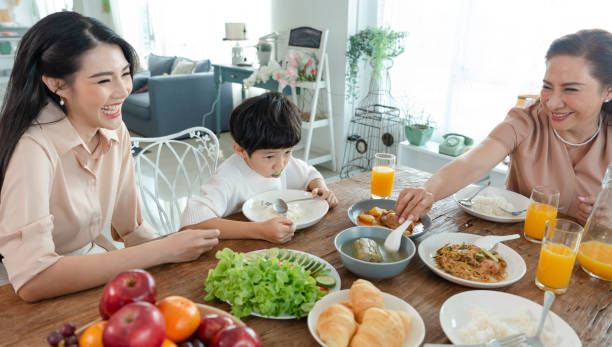 istock Asian happy family spend time having lunch on table together.  relationship and activity in house. 1396086731