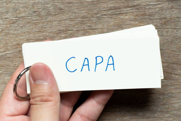 istock Man hold the flash card with handwriting word CAPA (abbreviation of corrective action and preventive action) on wood background 1396087311