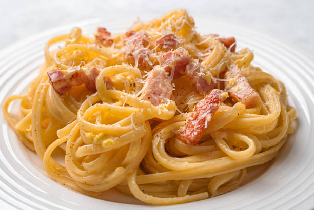 istock Pasta carbonara with bacon, cheese, cream and pepper close-up on a gray background. 1396087366