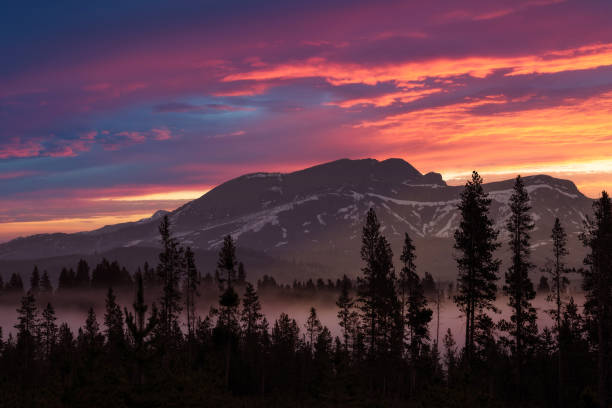 A colorful morning sky over a fog filled Madison River Valley in Montana stock photo