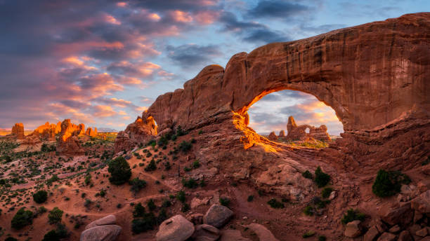 vue au coucher du soleil de turret arch en regardant à travers la fenêtre nord du parc national des arches - arches national park photos et images de collection