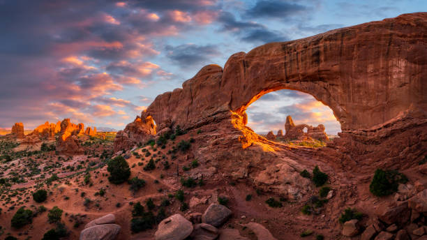 vue au coucher du soleil de turret arch en regardant à travers la fenêtre nord du parc national des arches - natural arch photos et images de collection