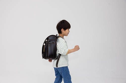 Little school boy preparing schoolbag for school