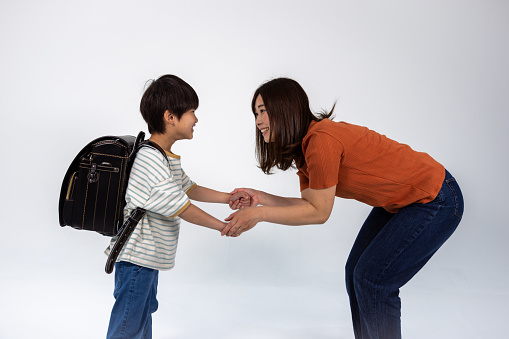 Studio shot of a first grade of elementary school child, happy carrying randoseru (Japanese style school back pack)