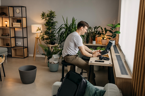 Man works on a laptop in his home office