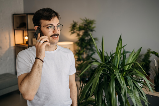 Man is talking on the phone in the living room