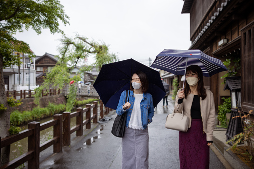 Female friends visiting traditional Japanese sightseeing place in a rainy day