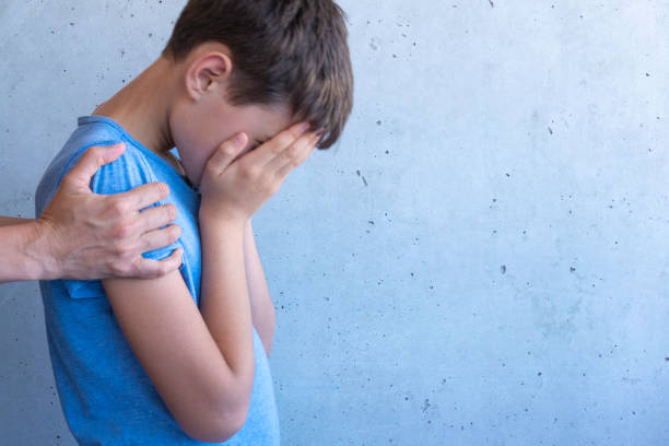 Mother hand hugging sad boy. Learning difficulties, family problems, bullying, depression, stress or frustration concept