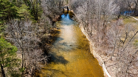 The water is no longer frozen. The river is open with water flowing. The trees in the forest are still bare. But spring has arrived and winter is gone