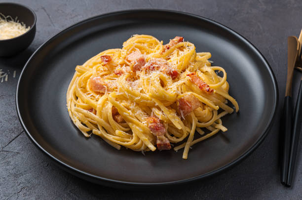 istock Pasta carbonara with bacon, cheese and egg on a dark background. 1396095422