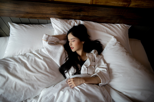 Top View of Beautiful Young Asian Woman sleeping cozily on bed at bedroom on night with sweet dream and sleep well Young beautiful girl get deep sleep on bed and feel relaxing in near morning