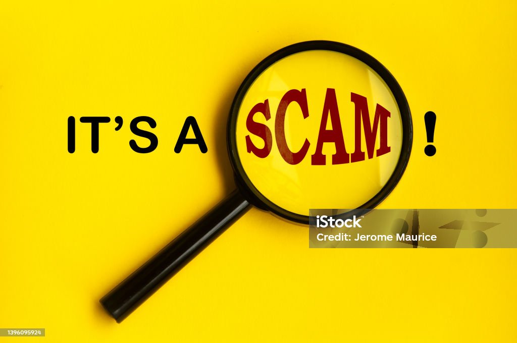 It's a scam text on yellow cover with magnifying glass. Scamming concept It's a scam text on yellow cover with magnifying glass. Scamming and fraud concept Scammer Stock Photo