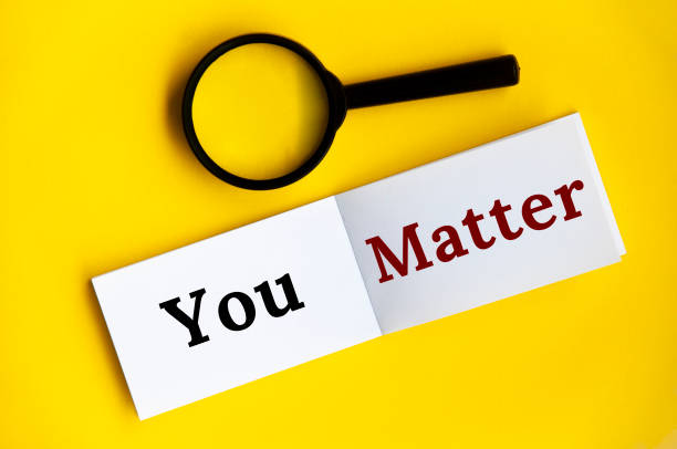 istock You matter text on notepad with magnifying glass on yellow cover background. 1396095956