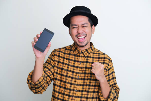istock Adult Asian man showing blank mobile phone screen with happy expression 1396097318
