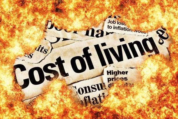 Inflation burns consumers: newspaper headlines about rising prices, consumed by fire stock photo