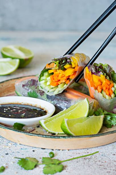istock Fresh Asian appetizer Spring rolls (Nem) made from rice paper and raw vegetables and herbs with hot sauce on a light blue background. Vietnamese Food 1396102038