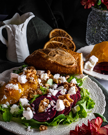 Superfood salad with sliced beets and oranges, feta cheese, and toasted walnuts on a bed of mixed greens. Served with a baguette