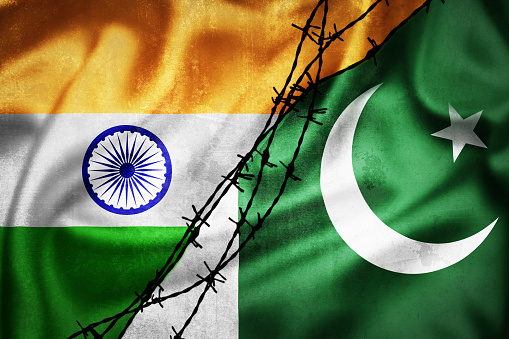 Grunge flags of India and Pakistan divided by barb wire illustration, concept of tense relations between India and Pakistan