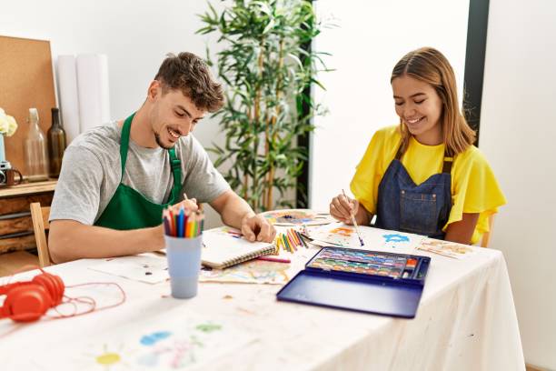 istock Young hispanic artist couple smiling happy drawing at art studio. 1396103461