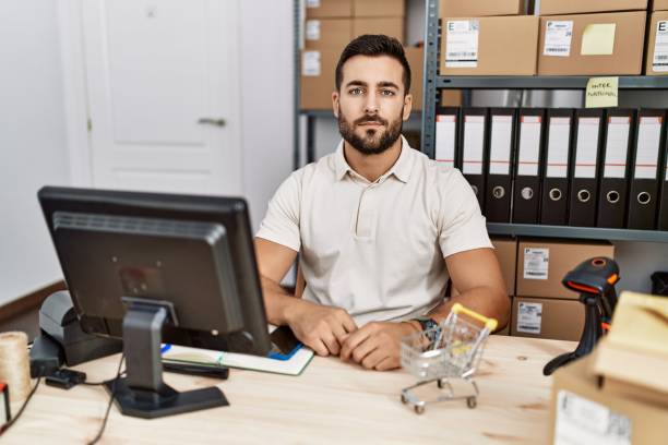 istock Handsome hispanic man working at small business commerce relaxed with serious expression on face. simple and natural looking at the camera. 1396105125