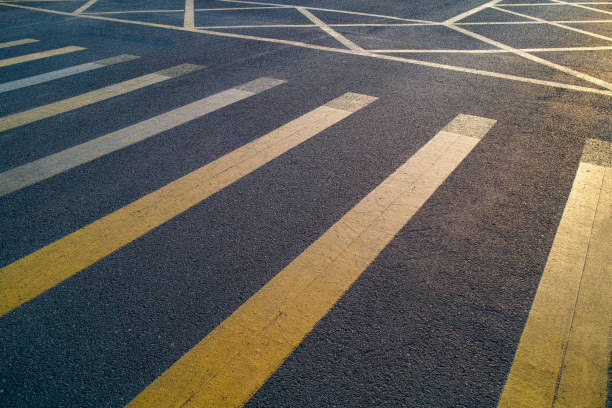 Crosswalk lines on the ground illuminated by sunlight in the morning