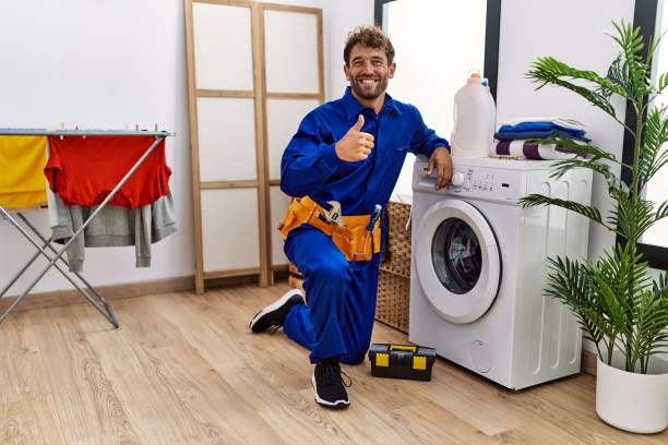 istock Young hispanic man working on washing machine smiling happy and positive, thumb up doing excellent and approval sign 1396107188