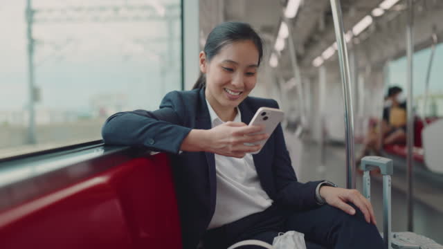 Businesswoman using smart phone on train