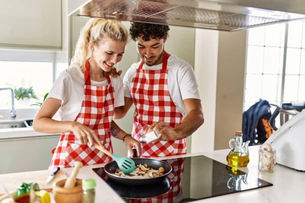 istock Young couple smiling happy cooking using frying pan at kitchen. 1396107542