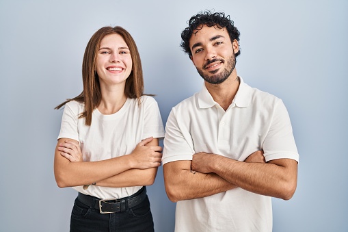 Portrait of two diverse young businesspeople smiling confidently while standing side by side together on a light background