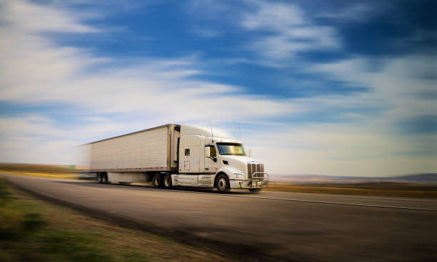 istock White semi-truck with cargo speeding - panning motion blur 1396109094