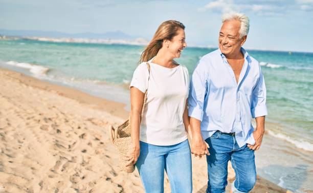 istock Middle age hispanic couple smiling happy walking at the beach. 1396109137