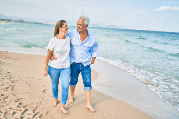 istock Middle age hispanic couple smiling happy and hugging walking at the beach. 1396109158