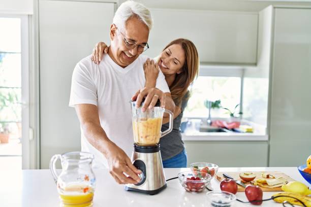 istock Middle age hispanic couple smiling happy and hugging cooking smoothie at the kitchen. 1396109231