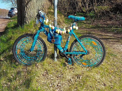 A bicycle has been decorated and stands on the side of the road