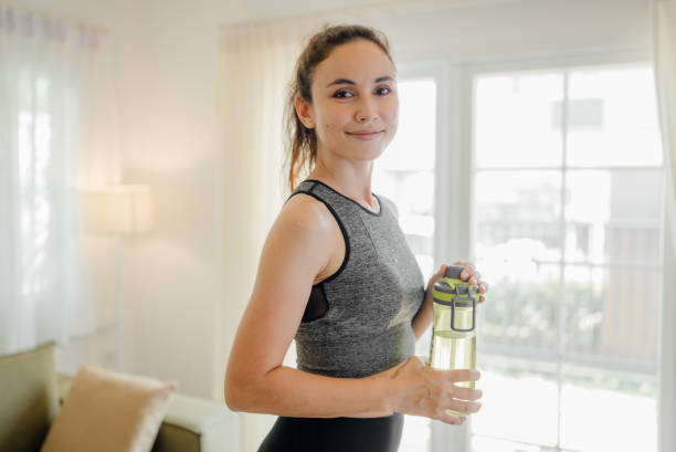 young woman practicing exercise at home - stretching women attractive female indoors imagens e fotografias de stock