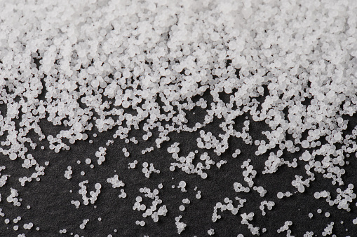 White many polymer granules on black matte background