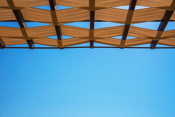 View of the wicker roof against the blue sky from below View of the wicker roof against the blue sky from below thatched roof hut straw grass hut stock pictures, royalty-free photos & images