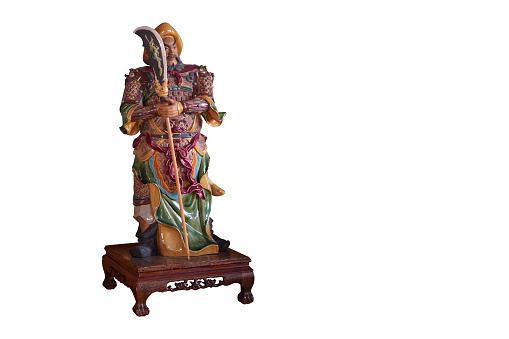 left side, statue guan Yu standing holding a halberd on a wooden table on white background, object, gift, religion, copy space